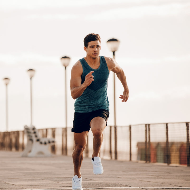 Man running on a wooden boardwalk with streetlights in the background