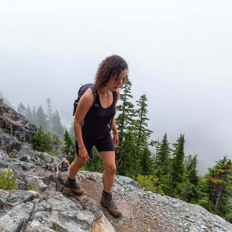 Person hiking on a rocky mountain trail with foggy background