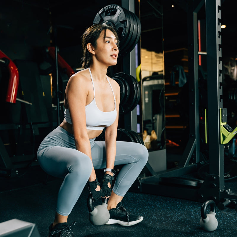 Woman exercising with weights in a gym setting
